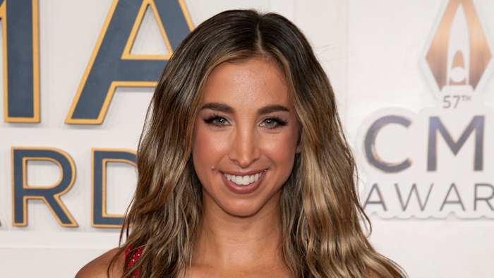 Katie Austin sports her light brown hair in a soft wave and smiles for her camera.